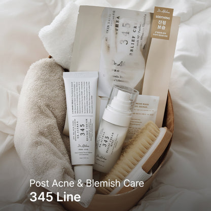 A post-acne and blemish care set from Dr. Alhanna's 345 Line, arranged in a wooden basket with a towel.